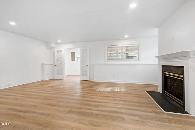 a view of empty room with wooden floor and fireplace