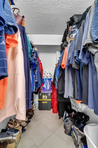 a view of walk in closet with clothes and shoes