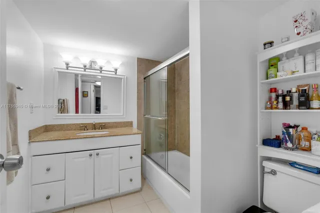 a bathroom with a granite countertop sink a large mirror and a bathtub