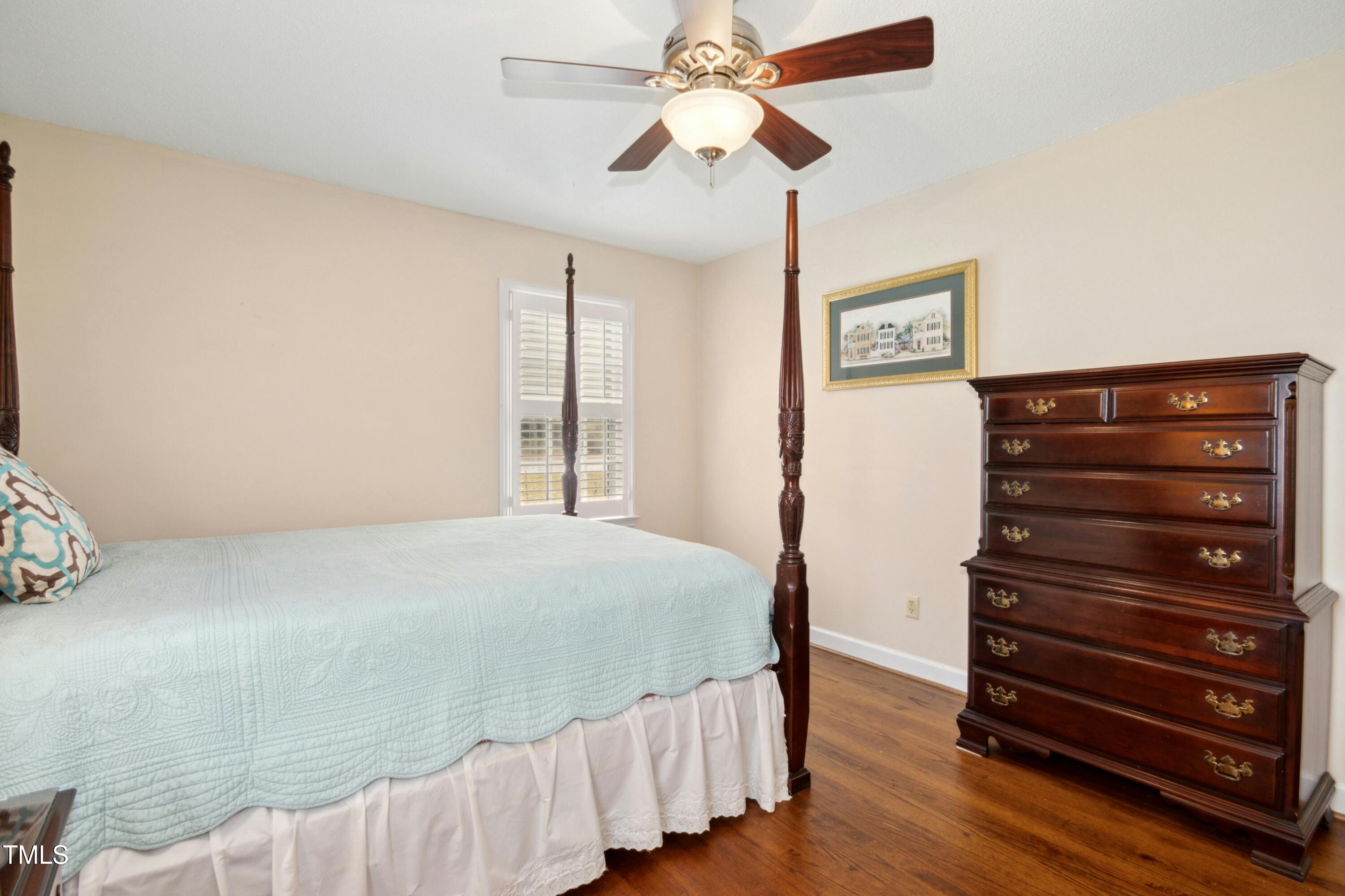 5405 Fireside Drive Raleigh, NC 27609 - Photo 18 of 29 a bedroom with a bed and wooden floor