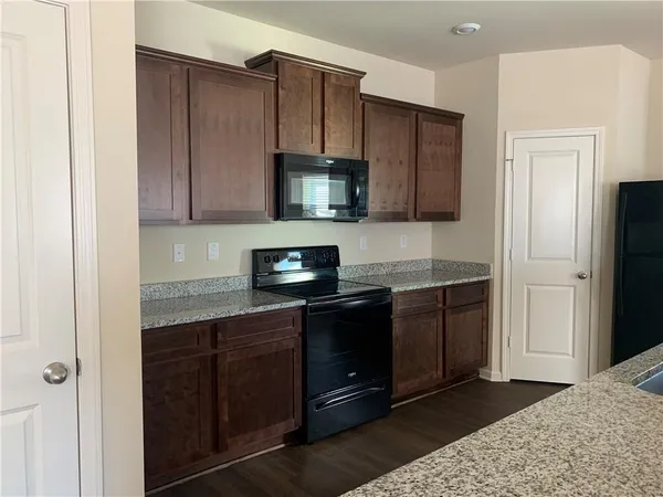 a kitchen with stainless steel appliances granite countertop wooden cabinets a stove top oven a sink and dishwasher