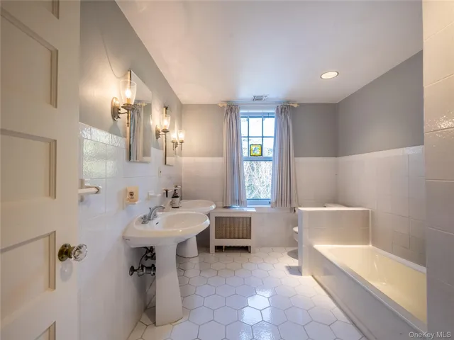 a bathroom with a sink bathtub and a mirror