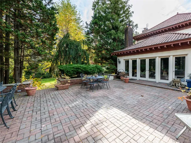 a view of a patio with table and chairs and potted plants with wooden floor and fence