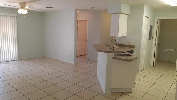 en empty room with window and chandelier fan