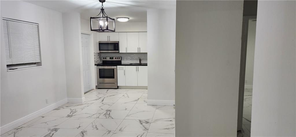 900 Southwest 11th Street, Unit 3 Hallandale Beach, FL 33009 - Photo 1 of 14 a view of a kitchen with microwave and refrigerator