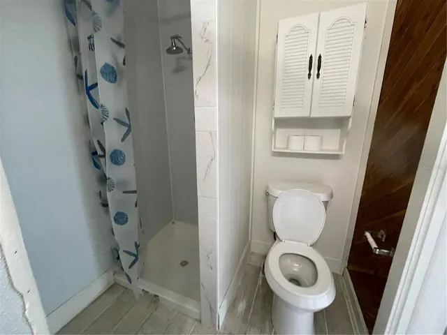 a bathroom with a toilet and a shower