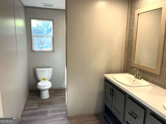 a bathroom with a toilet a sink and mirror