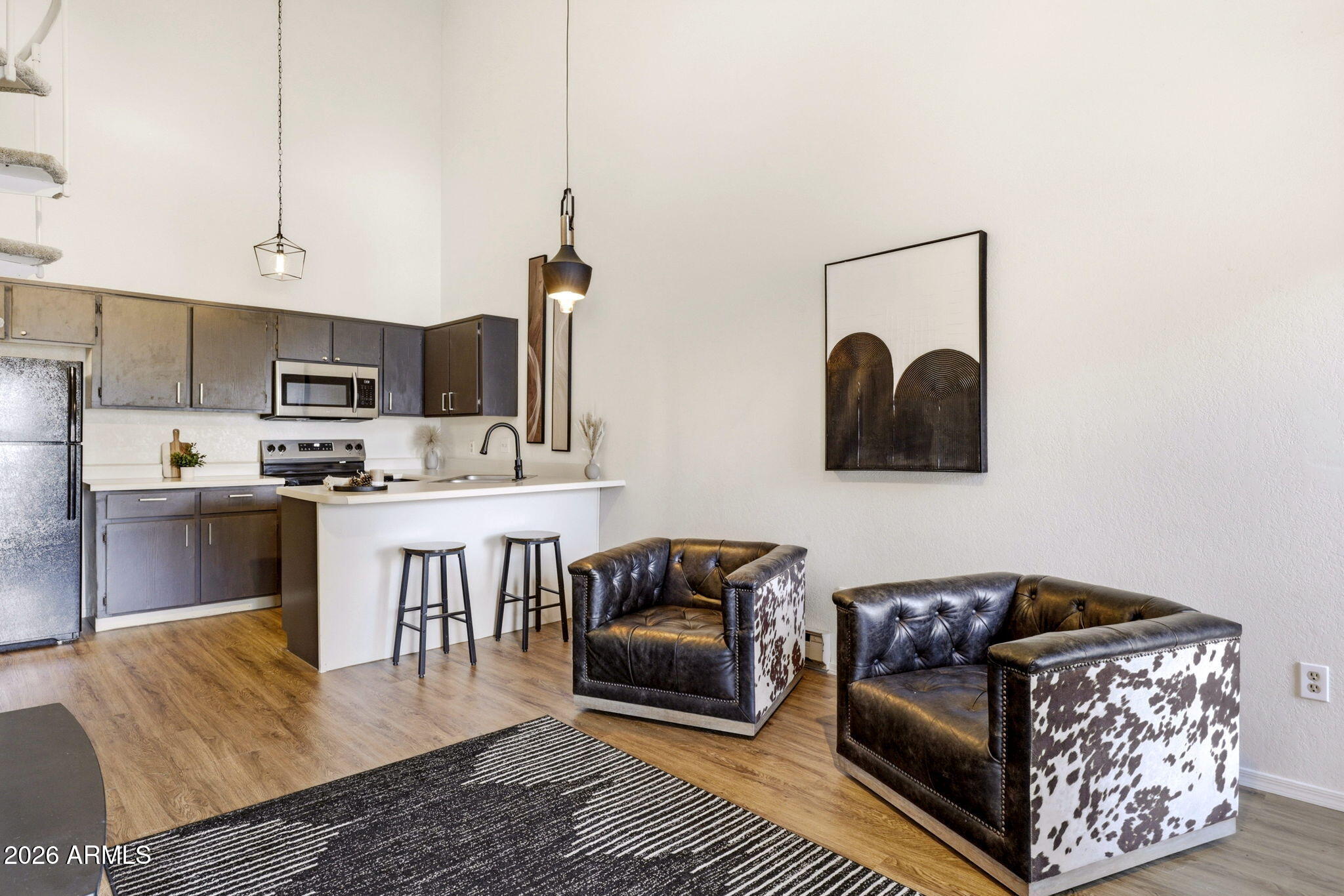 a living room with stainless steel appliances furniture and a kitchen view