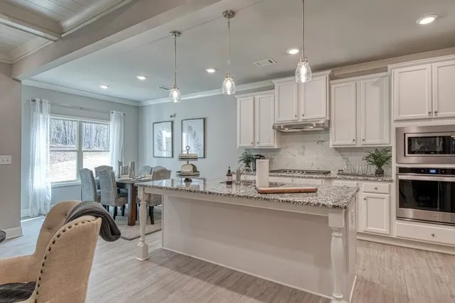 a kitchen with kitchen island granite countertop a sink cabinets and stainless steel appliances