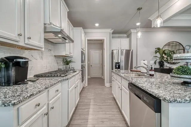 a large kitchen with granite countertop lots of counter space and stainless steel appliances