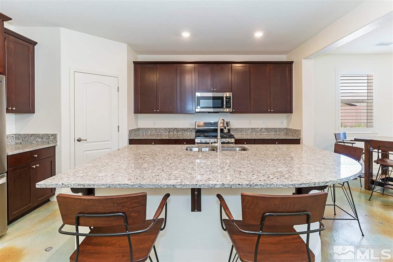 10150 Toltec Court Reno, NV 89521 - Photo 10 of 25 a kitchen with a table chairs sink and cabinets
