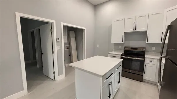 an empty room with a window and ceiling fan