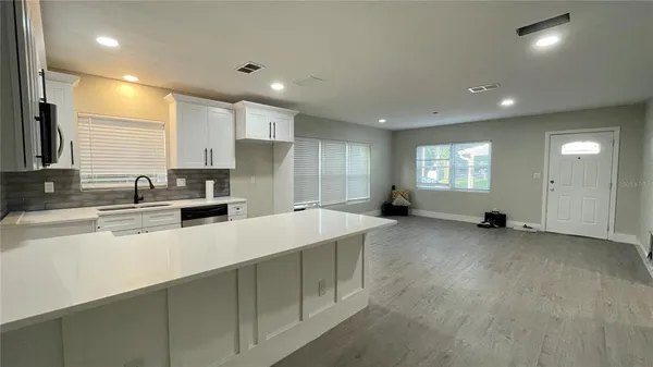 a large white kitchen with a large window
