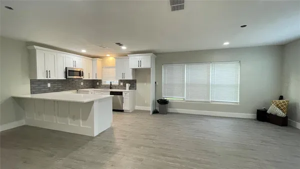 a large kitchen with kitchen island a sink stainless steel appliances and cabinets