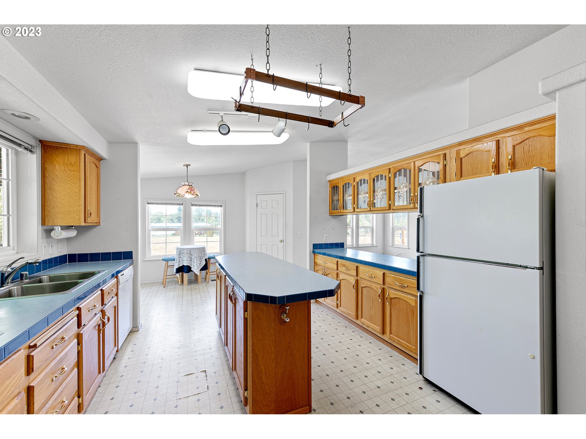 35796 Enterprise Road Creswell, OR 97426 - Photo 7 of 44 a kitchen with stainless steel appliances granite countertop a refrigerator a stove a sink dishwasher and white cabinets with wooden floor