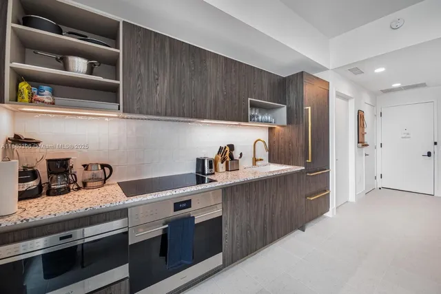 a kitchen with granite countertop a sink a stove and cabinets