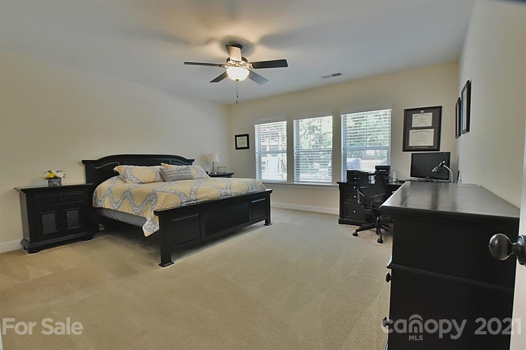 922 Castlewatch Drive Fort Mill, SC 29708 - Photo 20 of 38 a spacious bedroom with a bed and a chandelier