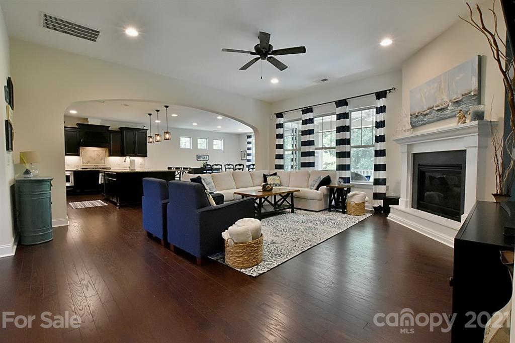 922 Castlewatch Drive Fort Mill, SC 29708 - Photo 5 of 38 a living room with stainless steel appliances kitchen island granite countertop furniture a fireplace a rug and a window