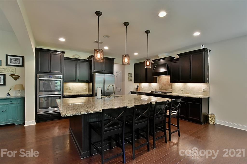 922 Castlewatch Drive Fort Mill, SC 29708 - Photo 8 of 38 a kitchen with stainless steel appliances kitchen island granite countertop a table chairs and a refrigerator