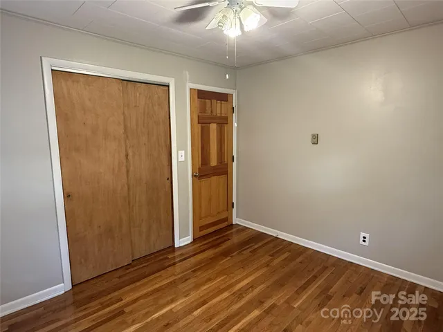 an empty room with wooden floor and closet area