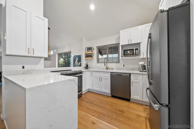 a kitchen with a sink cabinets stainless steel appliances and a window