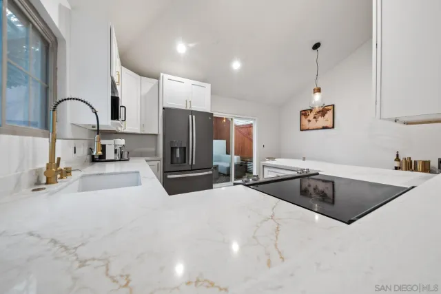 a kitchen with stainless steel appliances granite countertop a sink a stove and a refrigerator