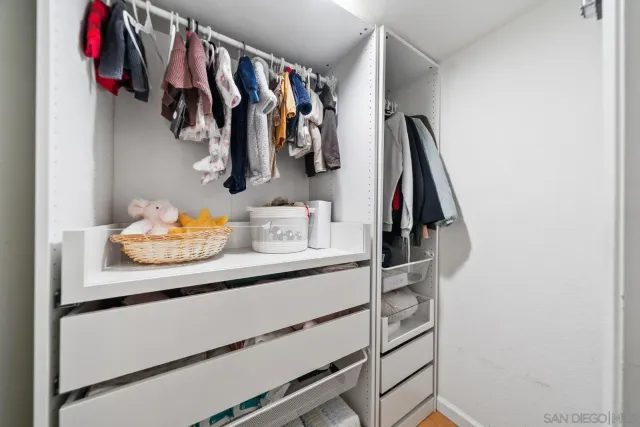 a view of walk in closet with clothes and shoes