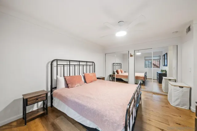 a bedroom with a bed and wooden floor