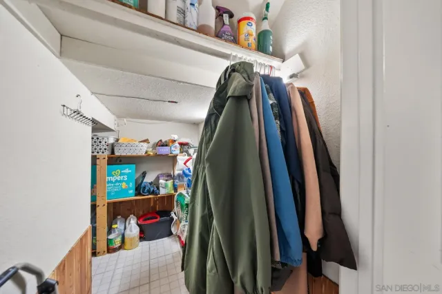 a view of walk in closet with clothes and shoes