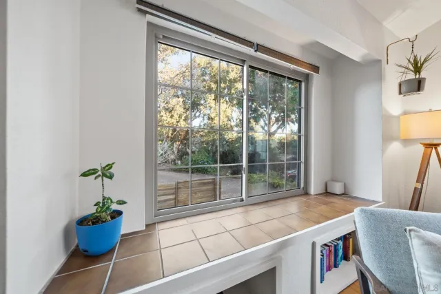 a room with a floor to ceiling window and an outdoor dining space