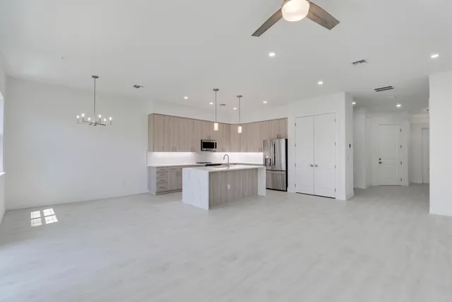 a kitchen with kitchen island a counter top space stainless steel appliances and cabinets