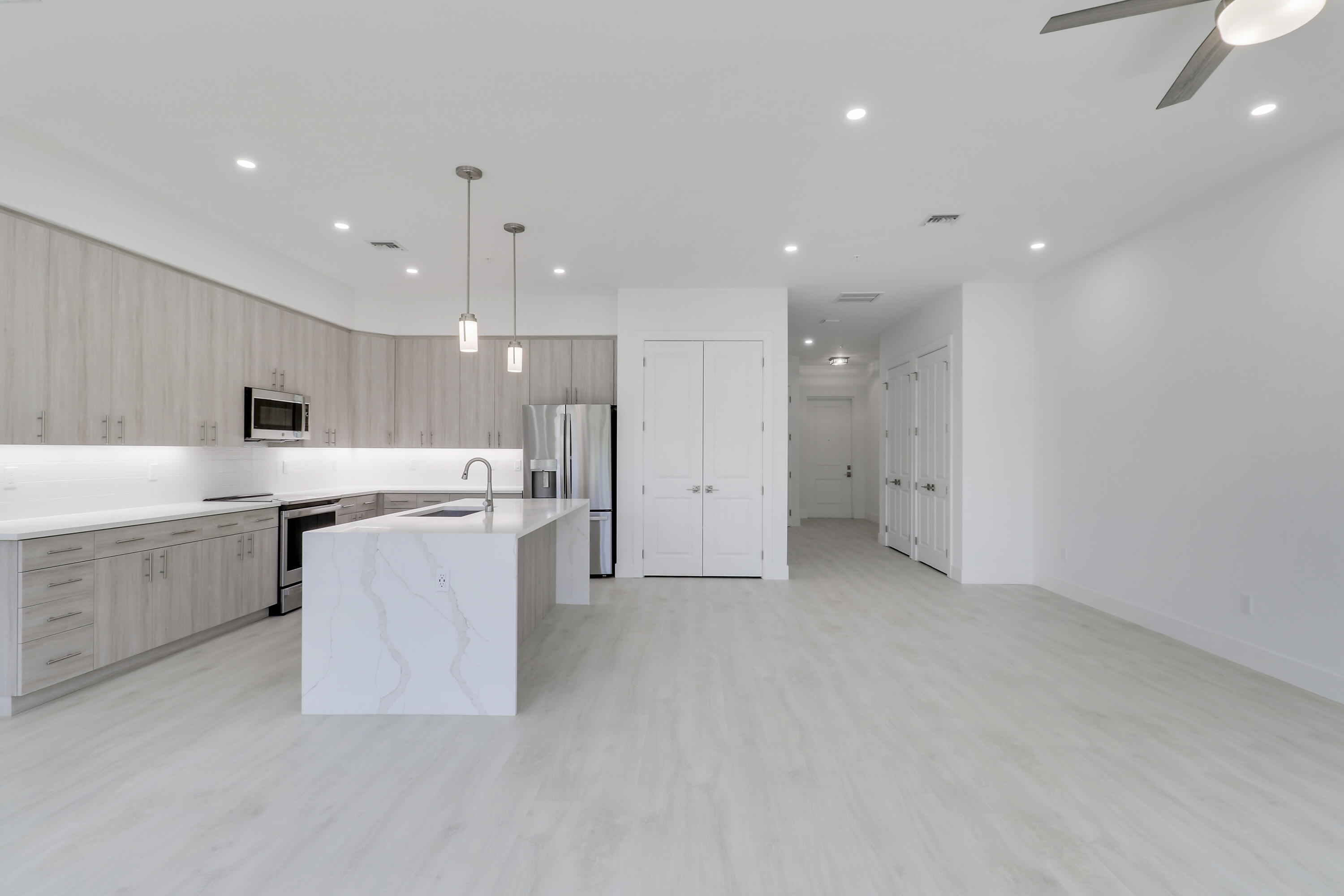 120 Water Pointe Place, Unit 3 Jupiter, FL 33477 - Photo 27 of 36 a large kitchen with a large counter top a sink stainless steel appliances and cabinets