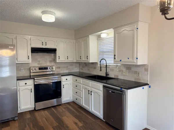 a kitchen with stainless steel appliances granite countertop a stove and a sink