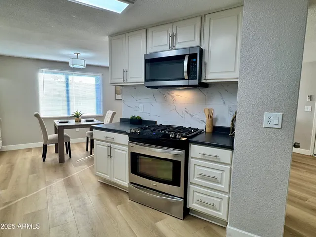 a kitchen with stainless steel appliances a stove a microwave and cabinets