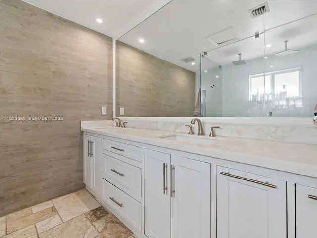 a bathroom with a double vanity sink a mirror and a