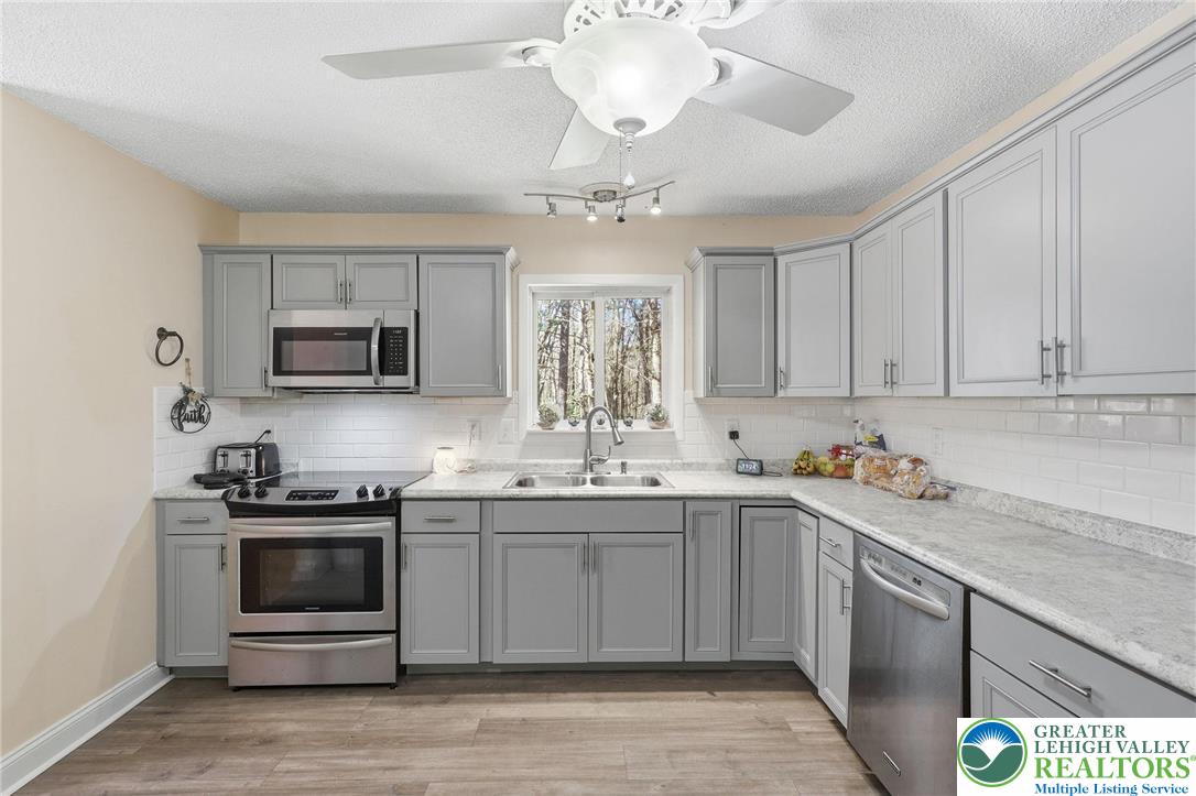 104 Scotch Pine Court Dingmans Ferry, PA 18328 - Photo 10 of 41 a kitchen with a sink stove and microwave
