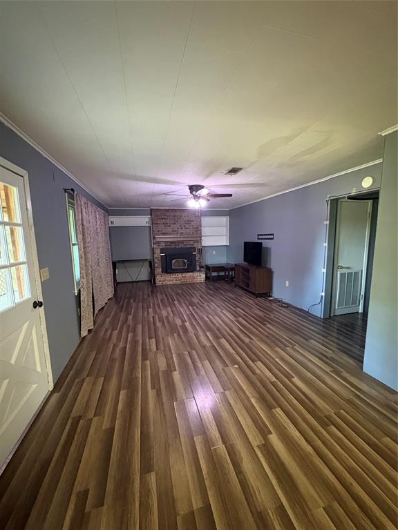 175 Marie Road Ringgold, LA 71068 - Photo 3 of 21 Spacious living area featuring wood-finish flooring, a brick fireplace with a dark-toned insert, a ceiling fan, and painted walls