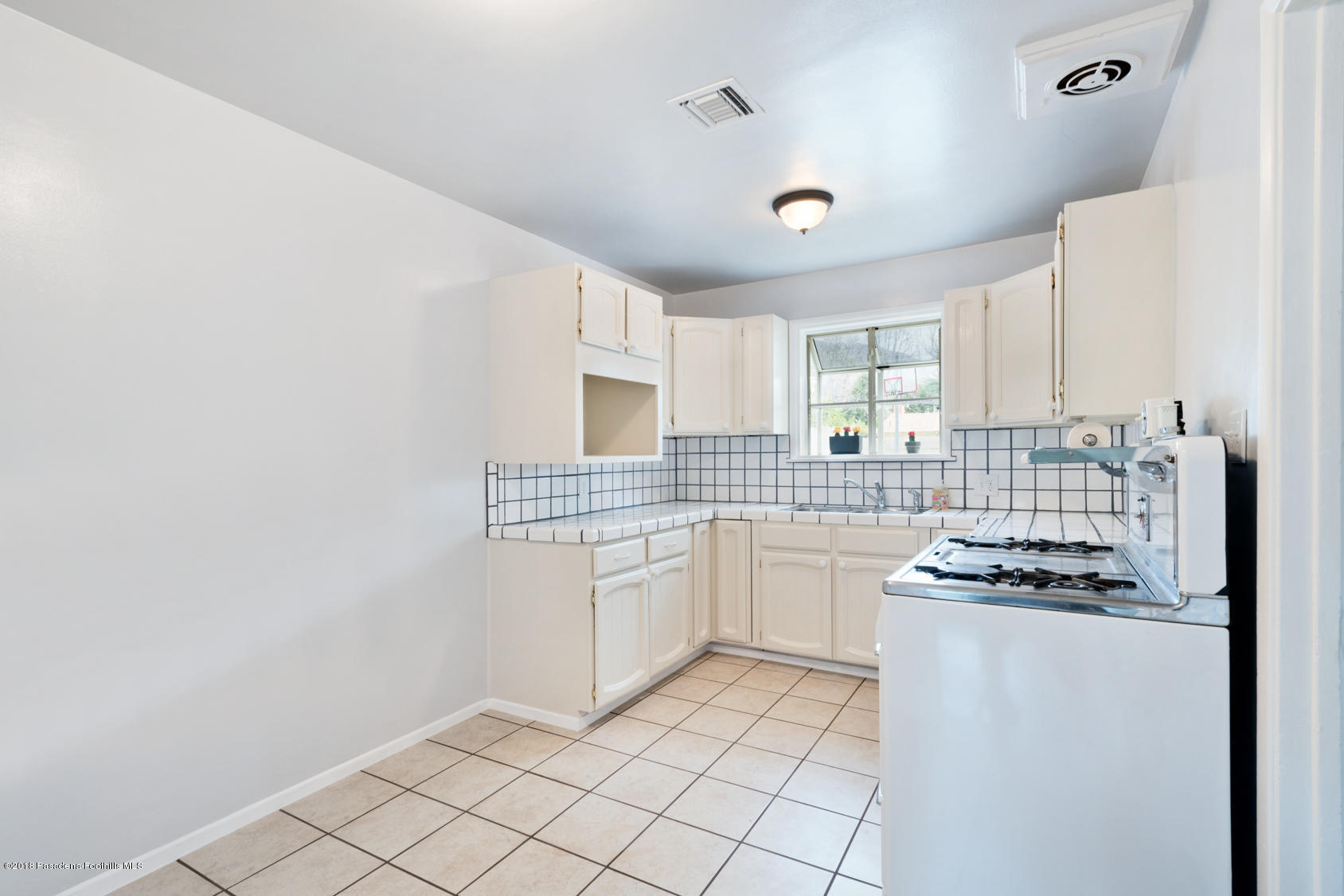4286 Aralia Road Altadena, CA 91001 - Photo 13 of 22 a kitchen with cabinets and white appliances