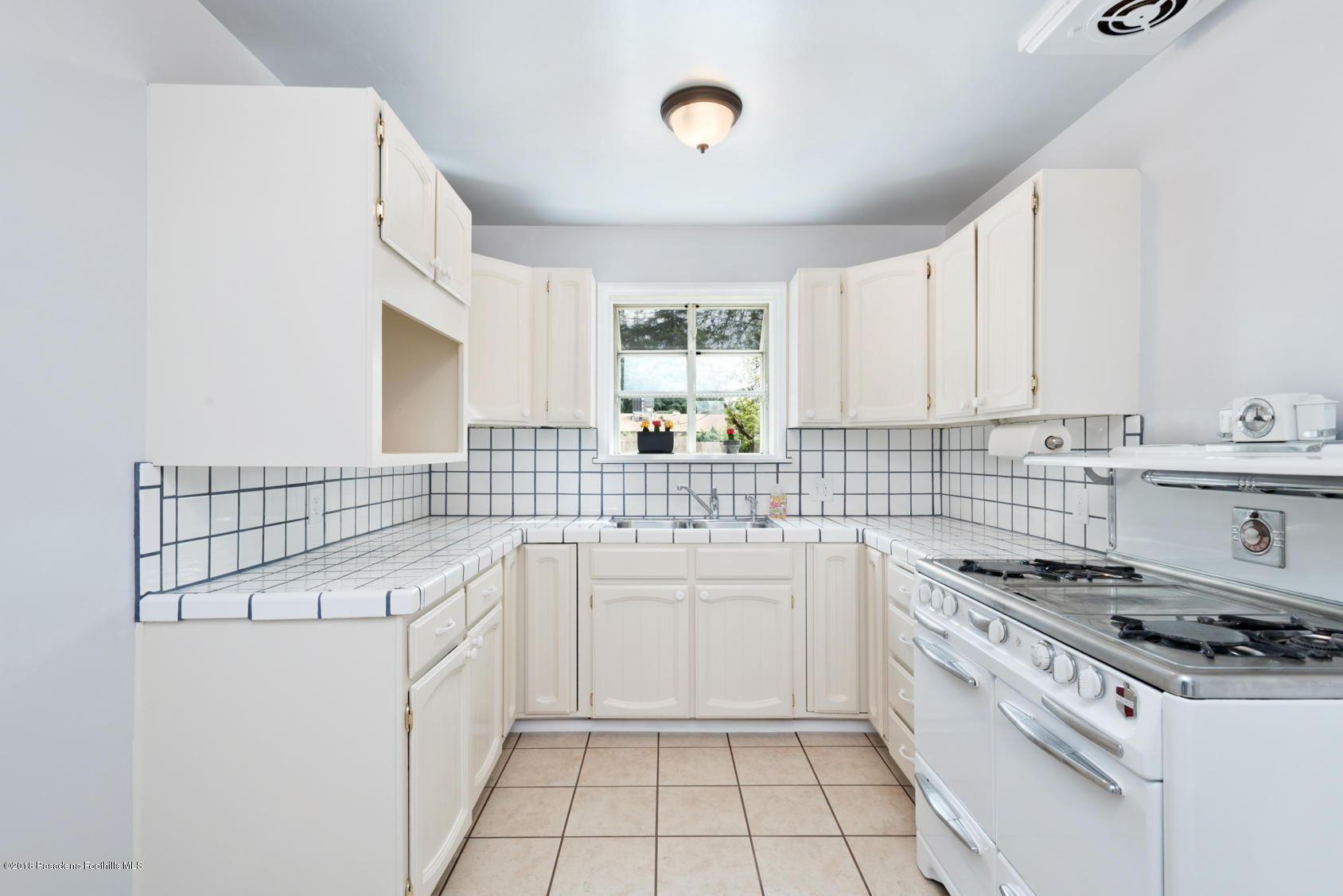 4286 Aralia Road Altadena, CA 91001 - Photo 14 of 22 a kitchen with a stove a sink and a refrigerator