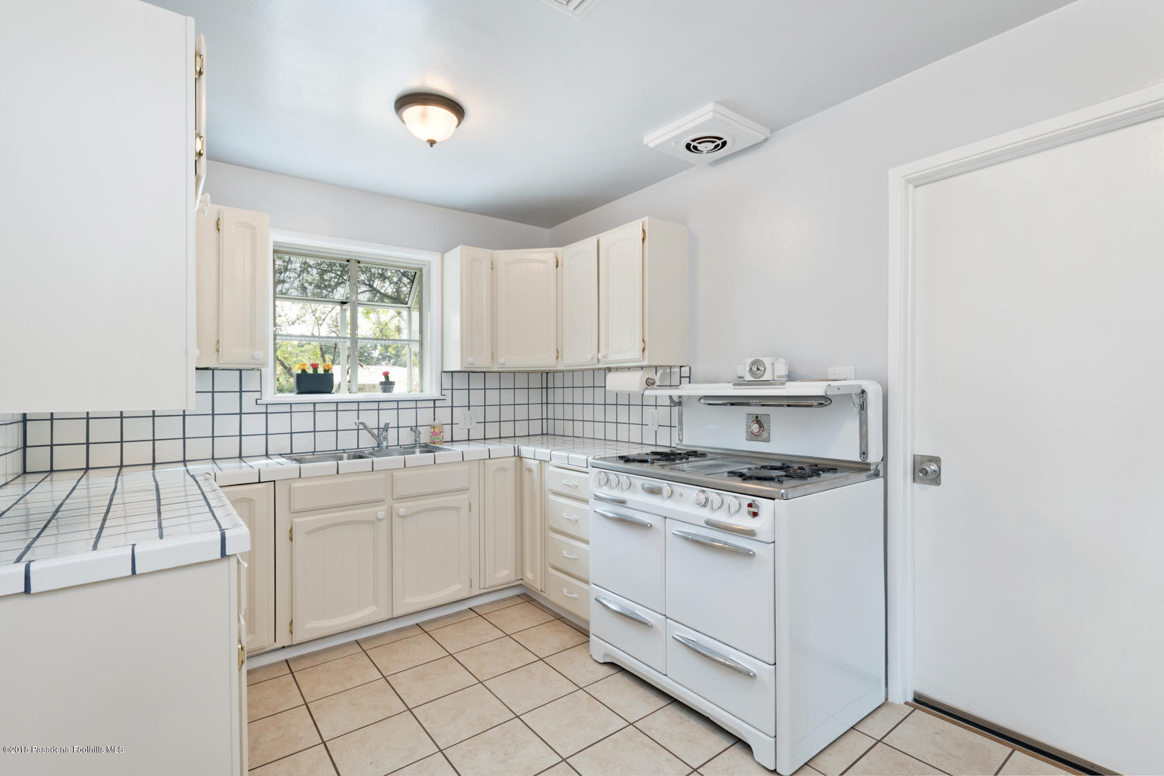 4286 Aralia Road Altadena, CA 91001 - Photo 4 of 22 a kitchen with a sink stove and cabinets