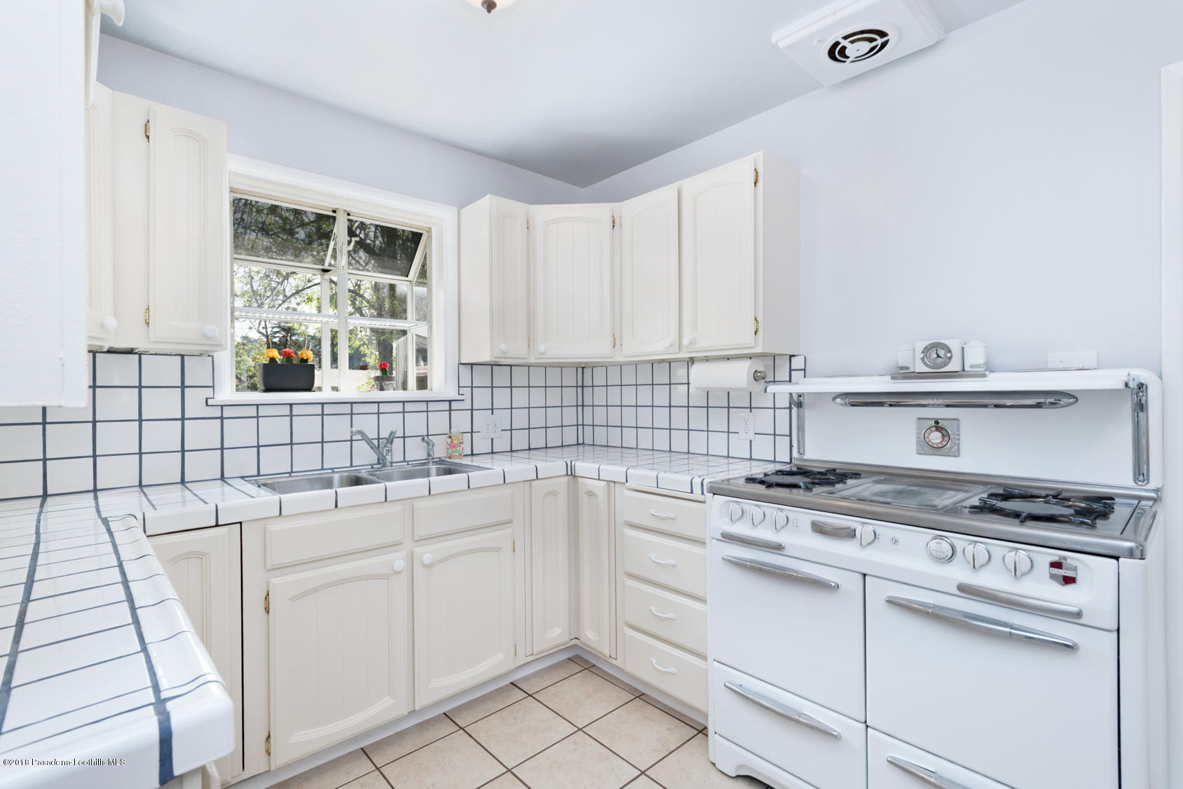 4286 Aralia Road Altadena, CA 91001 - Photo 10 of 22 a kitchen with white cabinets appliances and a sink