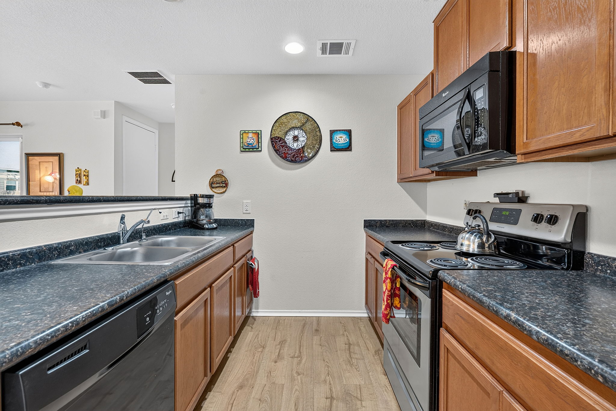 9004 Wiley Way Austin, TX 78747 - Photo 12 of 39 Warm wood cabinetry and dark countertops define this functional kitchen layout.