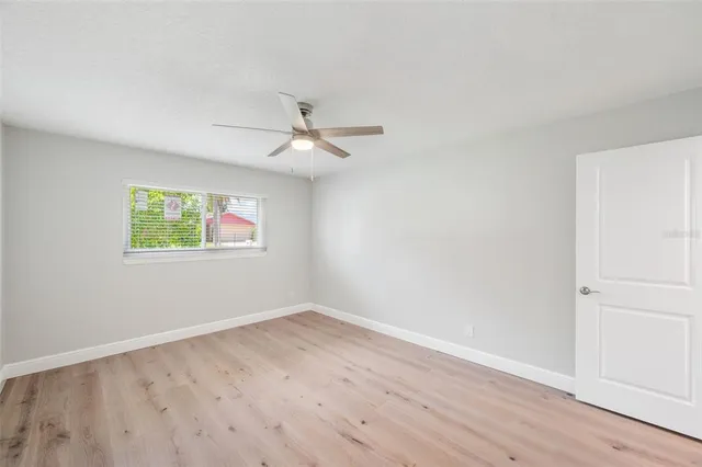 an empty room with closet and ceiling fan