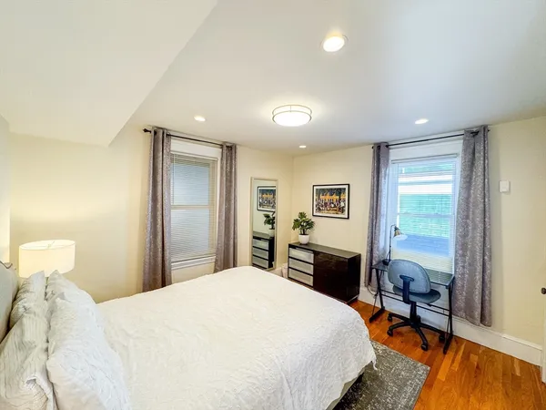 a bedroom with a bed and wooden floor