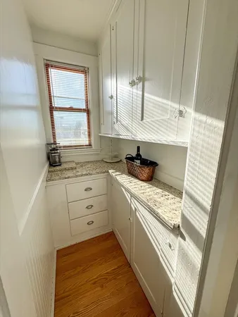 a kitchen with white cabinets and window