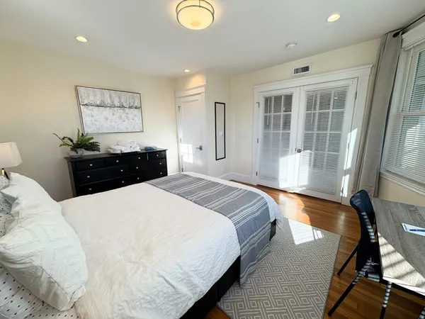 a bedroom with a bed and wooden floor