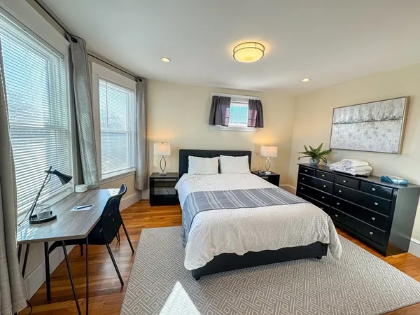 a bedroom with a bed and wooden floor