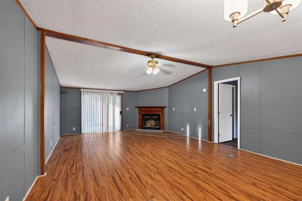 205 Wilson Road Stockbridge, GA 30281 - Photo 3 of 18 a view of an empty room with wooden floor fireplace and a window