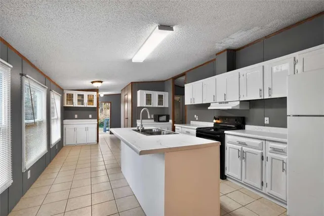 a kitchen with stainless steel appliances a stove refrigerator sink and cabinets