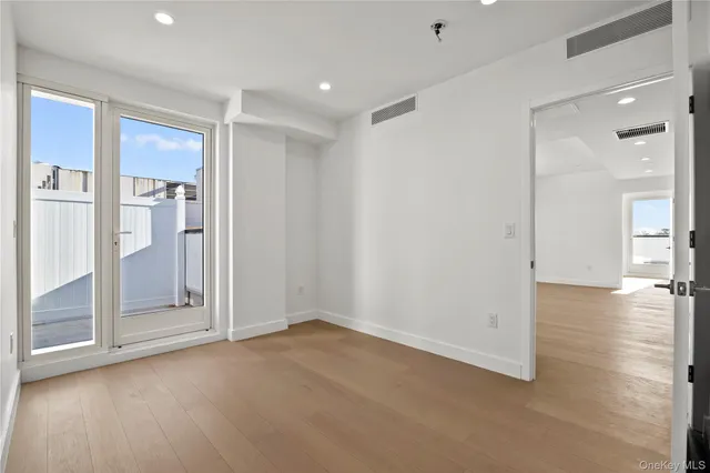 a view of a livingroom with wooden floor and a bathroom